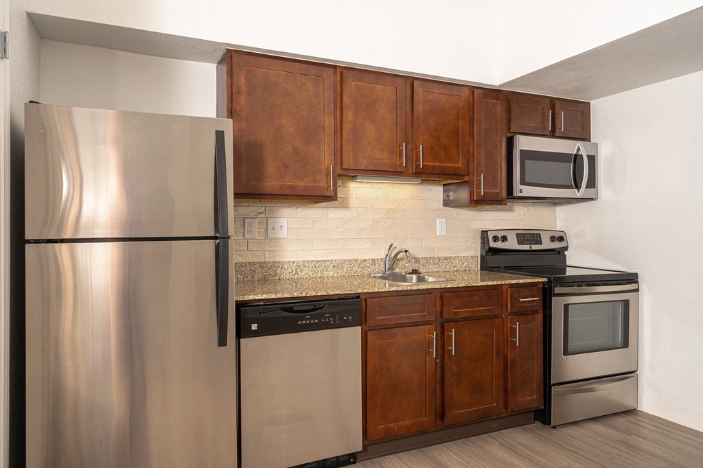 a kitchen with wooden cabinets and stainless steel appliances